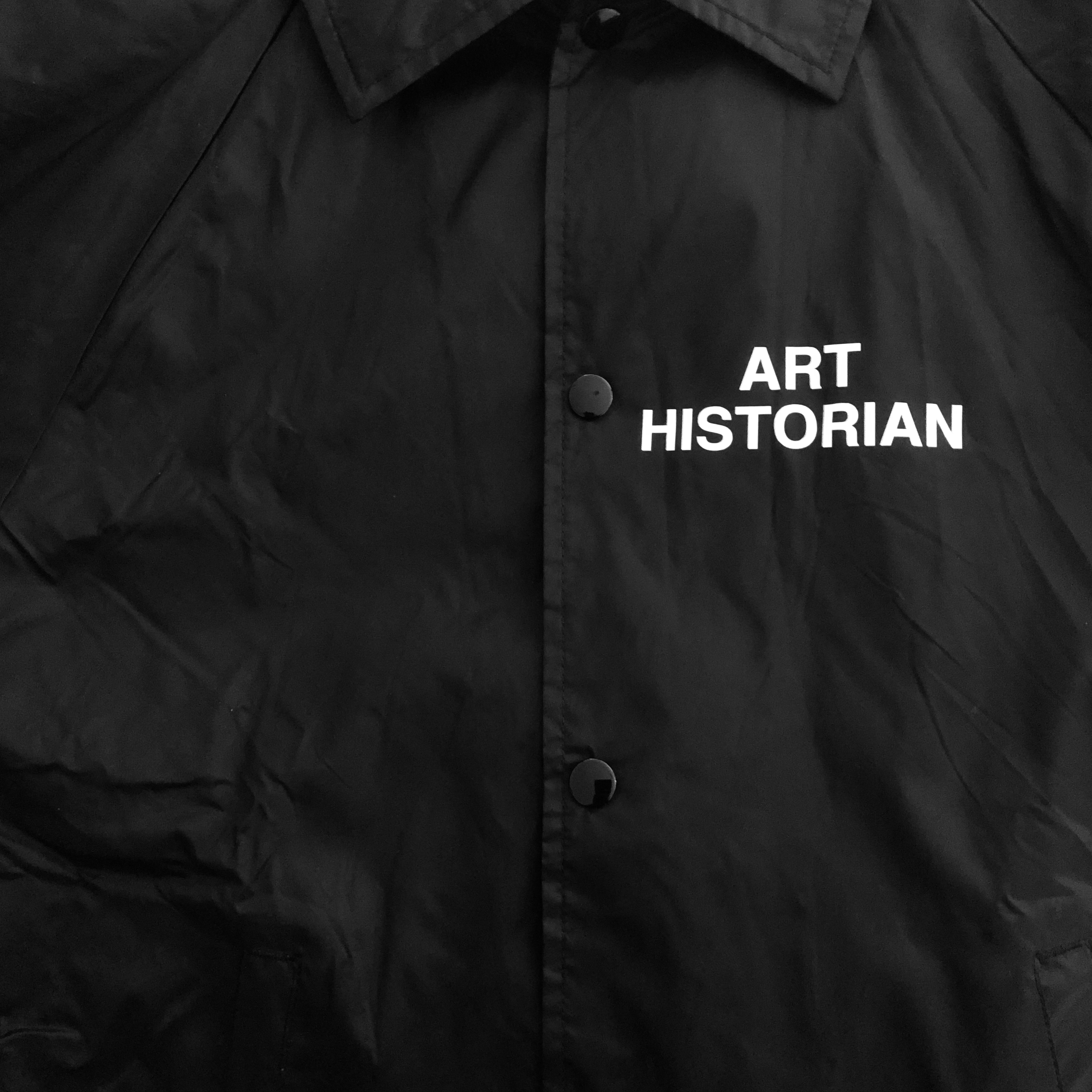 A close-up of the front of the jacket, with 'art historian' near the buttons, below the collar.